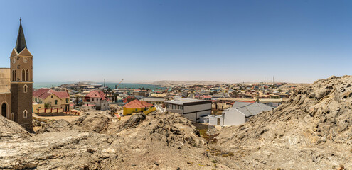 Colorful colonial buildings in Lüderitz, a small coastal town in Namibia, facing the Atlantic Ocean. Historic German architecture contrasts with desert landscapes, harbor views. © coffeinlix 