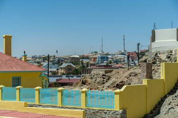 Colorful colonial buildings in Lüderitz, a small coastal town in Namibia, facing the Atlantic Ocean. Historic German architecture contrasts with desert landscapes, harbor views. © coffeinlix 