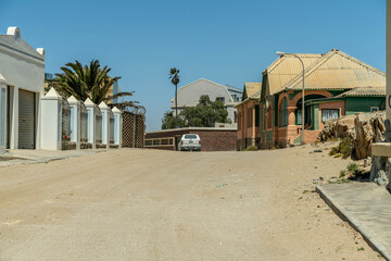 Colorful colonial buildings in Lüderitz, a small coastal town in Namibia, facing the Atlantic Ocean. Historic German architecture contrasts with desert landscapes, harbor views. © coffeinlix 