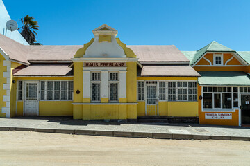 Colorful colonial buildings in Lüderitz, a small coastal town in Namibia, facing the Atlantic Ocean. Historic German architecture contrasts with desert landscapes, harbor views. © coffeinlix 
