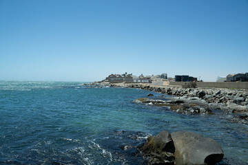 Colorful colonial buildings in Lüderitz, a small coastal town in Namibia, facing the Atlantic Ocean. Historic German architecture contrasts with desert landscapes, harbor views. © coffeinlix 