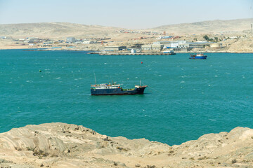 Colorful colonial buildings in Lüderitz, a small coastal town in Namibia, facing the Atlantic Ocean. Historic German architecture contrasts with desert landscapes, harbor views. © coffeinlix 