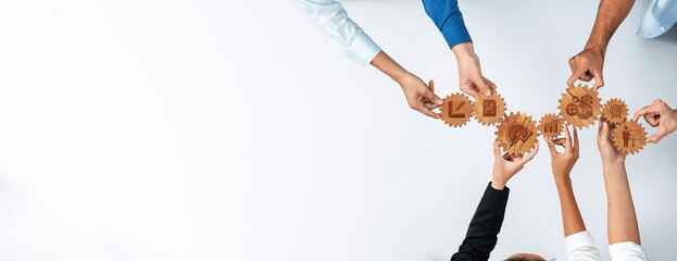 A dynamic image showing diverse hands collaborating and holding gears with charts and analytics, symbolizing teamwork and innovative business strategy in a professional environment. Amity