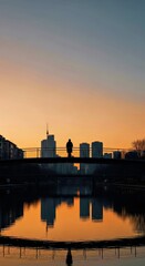 Naklejka premium Serene City Skyline Sunset Bridge Over Reflective Calm Water.jpg