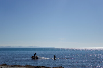 Fishermen along the Durr&euml;s, Albania seafront carry on a timeless tradition, casting their nets against the backdrop of the Adriatic Sea.