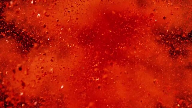Macro shot of red chili powder exploding into a cloud, vibrant red color, black background, energetic.