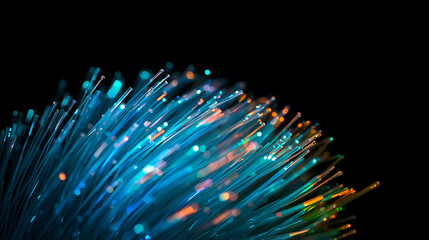 Closeup of colorful fiber optic cables with glowing blue and orange light on dark background