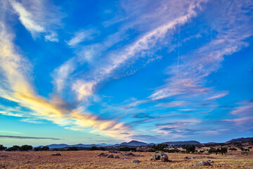 Stunning sunset sky over rural landscape in Extremadura, Spain with vibrant clouds and distant mountains