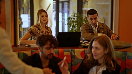 Young professionals collaborate during a productive business meeting, exchanging ideas and reviewing documents. The modern office setting fosters teamwork, communication, and strategic planning.