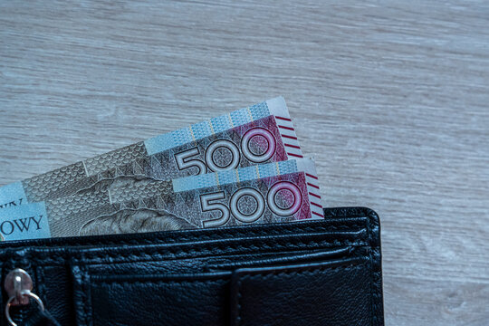 500 Zloty Polish Banknotes Partially Inserted in Black Wallet on Wood