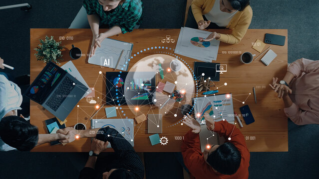 A diverse team of professionals engaging in a collaborative meeting focused on data analysis and artificial intelligence strategies inside a modern office setting. Trope - Powered by Adobe
