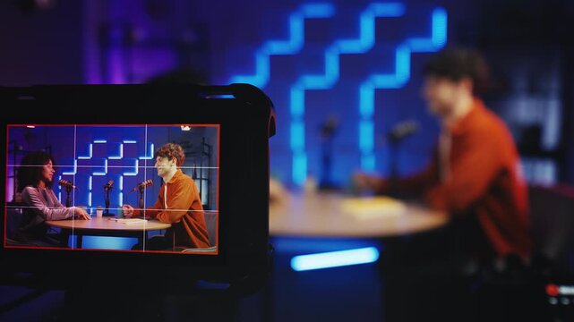 Male podcast host interviewing Black female guest in professional radio studio