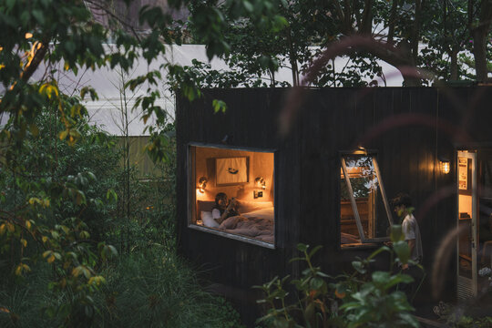 Cozy cabin retreat nestled amongst lush greenery illuminated warmly inside a nature escape