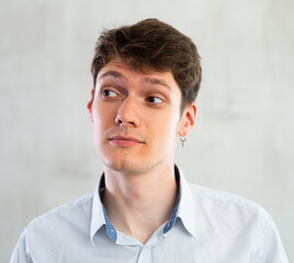 Portrait of young puzzled guy in studio