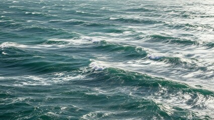 Deep blue ocean waves with white foam crests under natural light, creating a dynamic and textured surface.