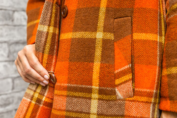  a woman unbuttons her coat, close-up. A woman unbuttons her coat. women's fingers fastening a button. woman putting on coat. fingers fasten a button. warm clothes