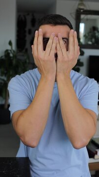 Shy surprised man covering his face 