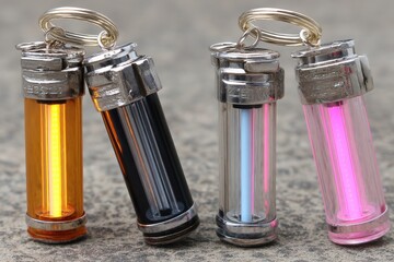 Four colorful keychain flashlights displayed together, showcasing different hues and metallic accents against a textured surface.