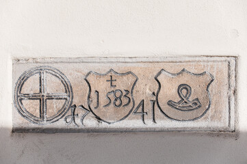 Historisches Steinrelief der alten M&uuml;hle in Neckartenzlingen mit M&uuml;hlrad, Wappen mit Hifthorn, Wappen mit Jahreszahl 1583 und Steinmetzzeichen und Jahreszahl 1741  