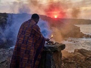 Ritual ceremony performed by man in traditional attire at sunset
