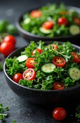 Two bowls of fresh kale salad with cherry tomatoes and cucumber slices. Healthy vegetarian meal is ready for eating. Nourishing food for diet.