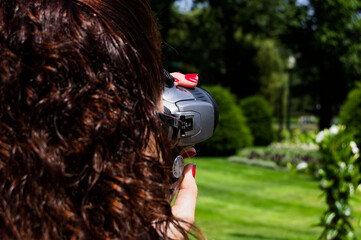 Outside Videography: Woman Filming with Video Camera in Lush Garden Background, Close-Up Shot
