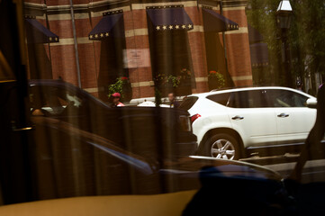 Urban Parking: Luxury Hotel Backdrop SUV Reflection in City Storefront Glass