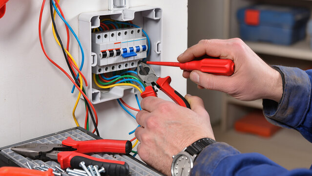 electrician fixing electrical wires in main fuse box 