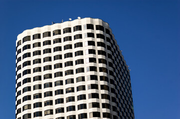 Modern Architecture: Towering Office Building with Curved Design and Blue Sky Vertical Lines