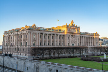 Obraz premium Seat of the Swedish parliament, in the old town, Stockholm, Sweden, with the swedish flag, blue sky, at dawn