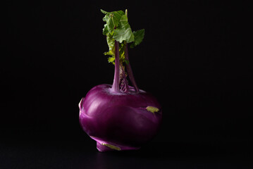 Ripe purple kohlrabi, freshly harvested from an organic farm, placed on a black background, is a healthy ingredient for cooking