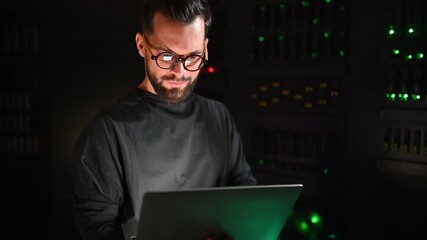 Male it specialist managing servers in data center with laptop - Powered by Adobe