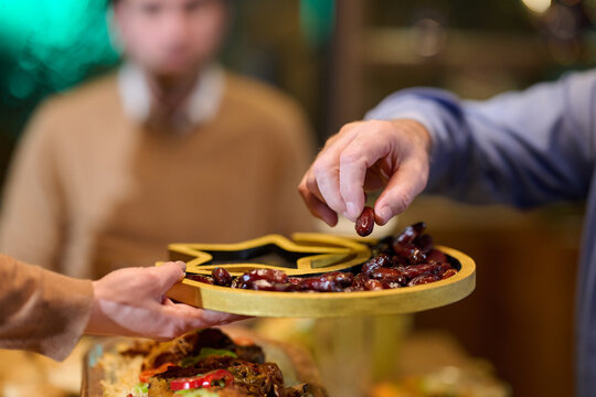 Families gather for iftar during Ramadan sharing dates and traditional food in a warm atmosphere