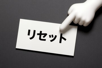 リセットと書かれたカードを指差す手元がやり直しや再出発を示すシンプルなイメージ