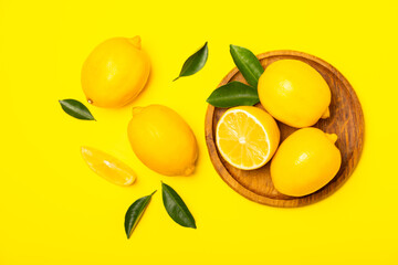 Lemon on a wooden table. Fresh lemon with a slice. Fresh lemon with citrus leaves. Lemon juice. Food and drink ingredients preparing. Healthy eating. Vitamin C. Space for text.