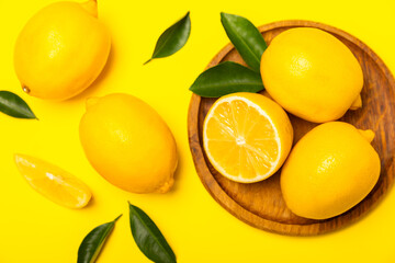 Lemon on a wooden table. Fresh lemon with a slice. Fresh lemon with citrus leaves. Lemon juice. Food and drink ingredients preparing. Healthy eating. Vitamin C. Space for text.