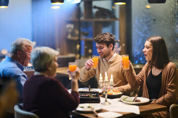Family gathers for iftar celebration during Ramadan with traditional food and drinks at a cozy restaurant setting