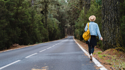 Obraz premium Woman on road through green forest on Tenerife, El Teide National Park, Canary Islands, Spain