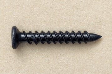 Black head self tapping screw with nail hole pointed tip and black metal heads on beige background.