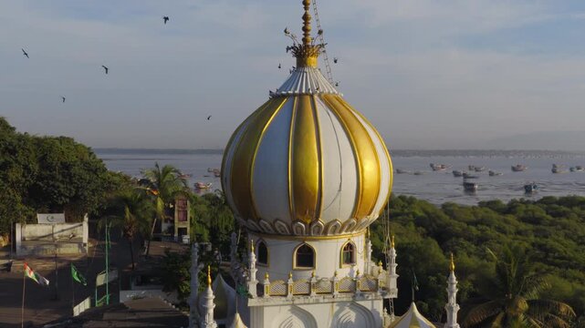 Medium distance circular drone shot of coastal domed mausoleum architecture