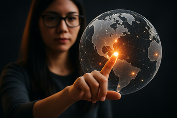 Woman pointing at glowing holographic globe with digital connection lines representing technology innovation