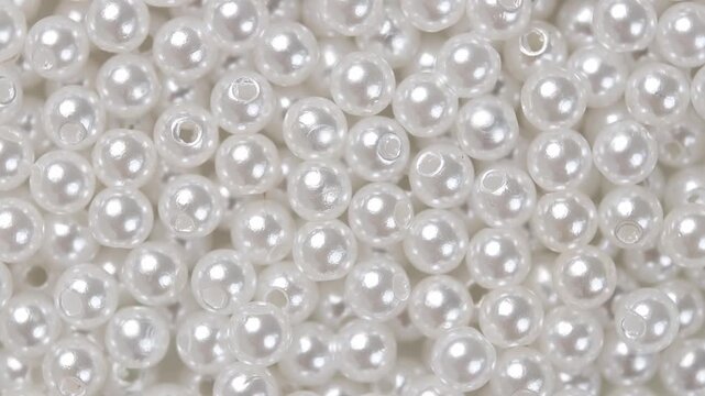 Pile of small artificial pearl beads rotating, looping motion