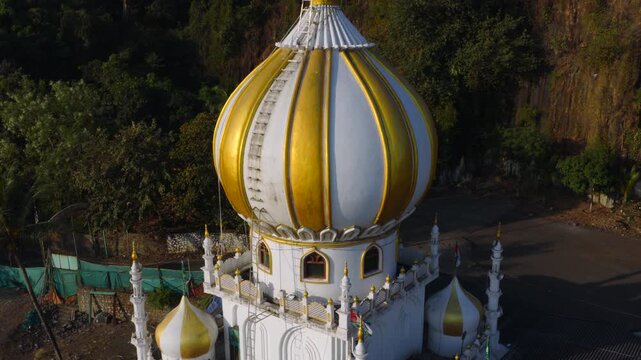 Aerial establishing shot of coastal domed mausoleum architecture in Mumbai