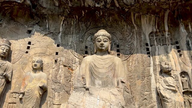 Tilt up shot of massive statue of Vairocana Buddha modeled after Empress Wu Zetian in Tang dynasty in Fengxian Temple Cave at Longmen Grottoes, Luoyang, Henan, China. UNESCO World Heritage.