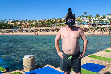 Man in Snorkeling Mask Standing on a Pontoon in the Red Sea, Embracing Adventure and the Beauty of Underwater Exploration.