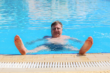 Adult Man Floating on His Back in the Pool of an Egyptian Hotel, Enjoying a Relaxing Day Under the Sun in a Tropical Paradise.