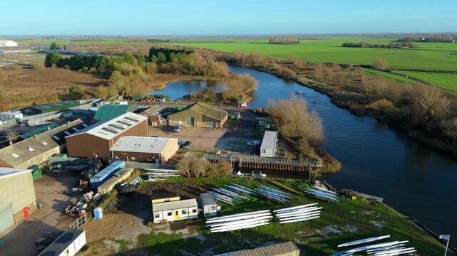 Aerial drone view of rowing club buildings and boats, sports rowing racing on riverbanks near Ely, united Kingdom. Winter sunny day