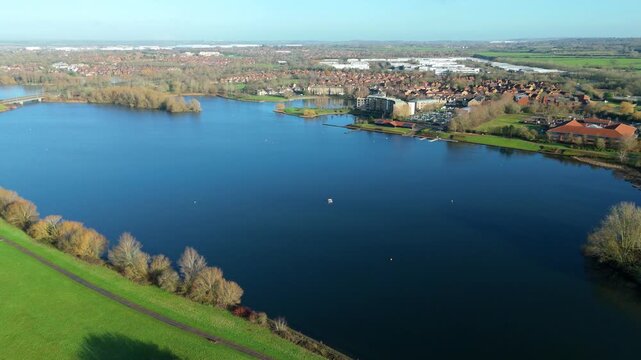 Cinematic Aerial View of Circular Water Pools and Modern Flats Around Caldecotte Lake Milton Keynes During Bright Winter Weather