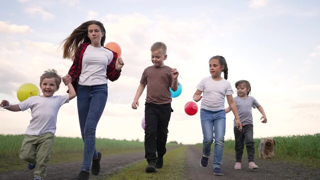 Child walk with balloon in field along dirt road holding hand with sibling while child play and smile and small dog follows nearby under open sky with cloud and green grass family walk together