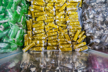 Pile of sweet green toffee called "Dodol Garut" in clear plastic wrappers. A famous Indonesian souvenir from Garut, West Java,  with a sticky texture and modern colorful look.